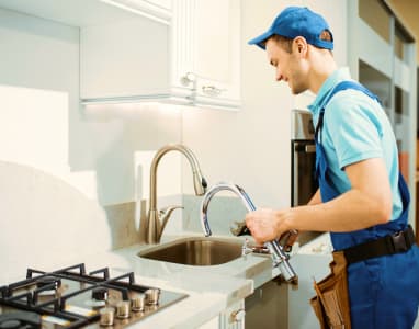 Plumber installing a kitchen faucet